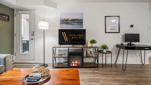 Un salon moderne avec une cheminée, un téléviseur et une bibliothèque.