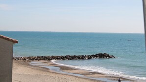 A beach with a rocky breakwater and calm water. - Waterfront studio, sea view 1st line beach (Palavas)
