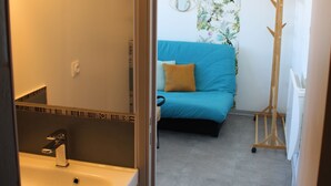 A bathroom with a sink, mirror, and vanity. - Waterfront studio, sea view 1st line beach (Palavas)