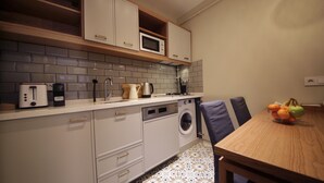 Eine kleine Küche mit Mikrowelle, Toaster und Waschmaschine.