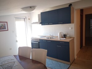 Departamento familiar, 2 habitaciones, balcón, vista al jardín | Cocina privada | Refrigerador, horno, parrilla de estufa y tetera eléctrica 