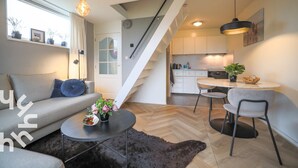 Un espacio habitable moderno con sofá, mesa de centro y zona de comedor.