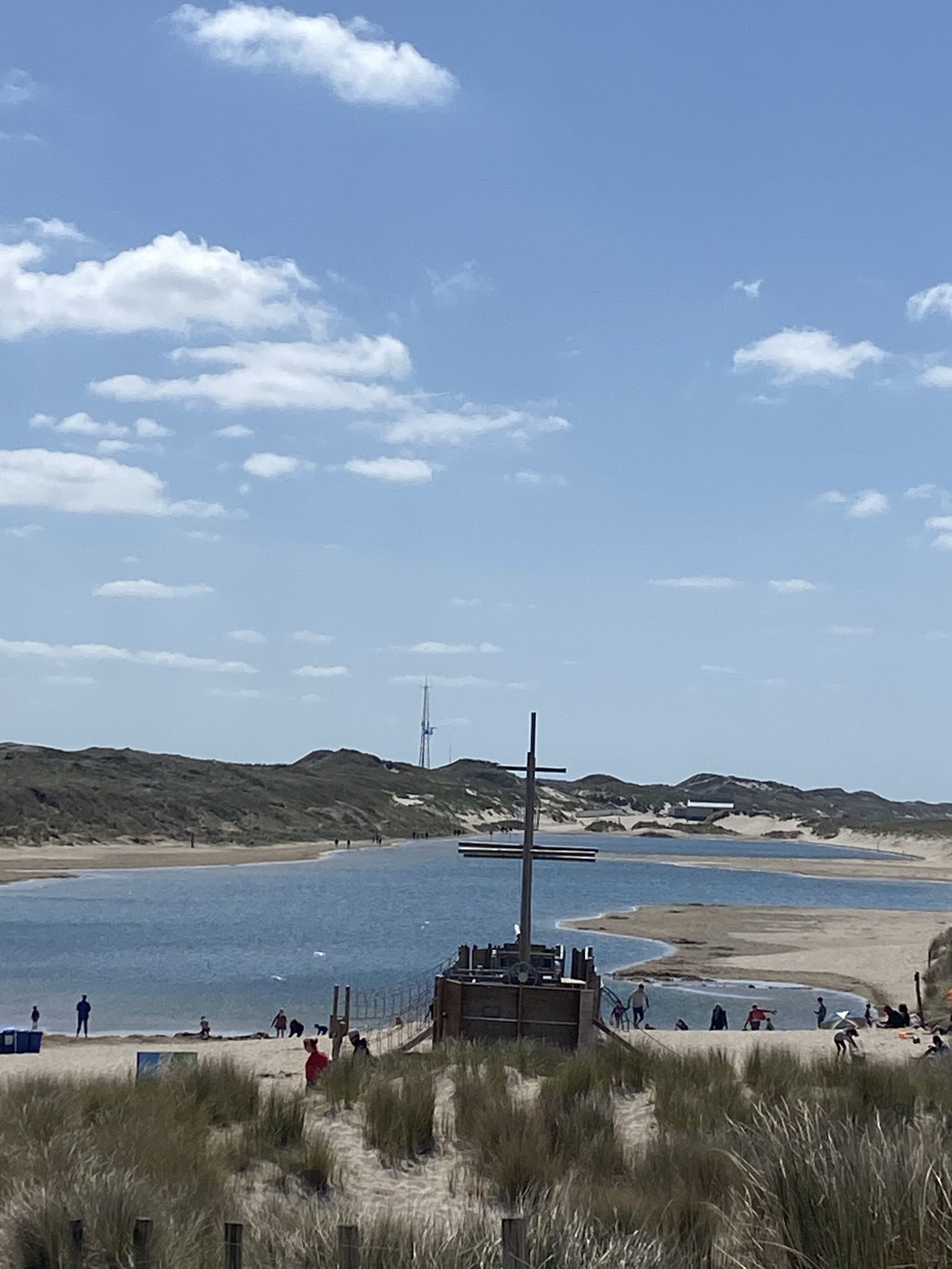 A beach with a sandy shore, a wooden structure, and a body of water.