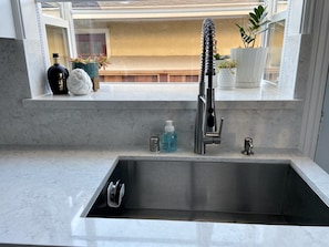 Enjoy a kitchen with a sleek sink, white countertop, and a view of the outdoor area.