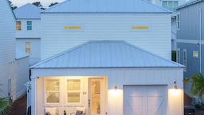 Ein zweigeschossiges Haus mit überdachter Veranda und Garage.