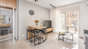 A modern kitchen with a dining area, a TV, and a large window. - Stylish one BDR with balcony (Jerusalem)