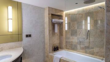 A modern bathroom with a glass-enclosed shower, a standalone bathtub, and a vanity with a mirror.