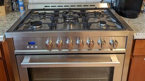 Una cocina con estufa, horno y campana de acero inoxidable.