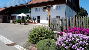 A hotel with a white facade, a wooden fence, and a sign indicating a seasonal stay. - Vacation Apartment for a Relaxing Getaway (Argenbühl)