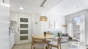 Un comedor moderno con una mesa redonda, sillas de madera y una lámpara colgante.