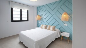 Un dormitorio con cama, mesita de noche y pared con diseños geométricos.