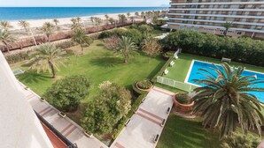 Un hôtel doté d’une piscine, de palmiers et offrant une vue sur la plage et l’océan.