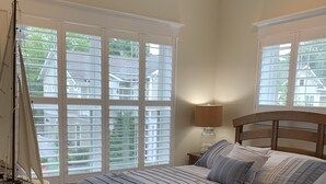 A bedroom with a large bed, a nightstand, a lamp, and a sailboat model. - 5 Bed on Cul-de-sac Downtown. Playground, Kayak Launch, Bike trails 1/2 block aw (Rehoboth Beach)