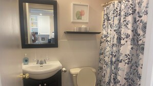 A bathroom with a sink, toilet, and shower curtain.