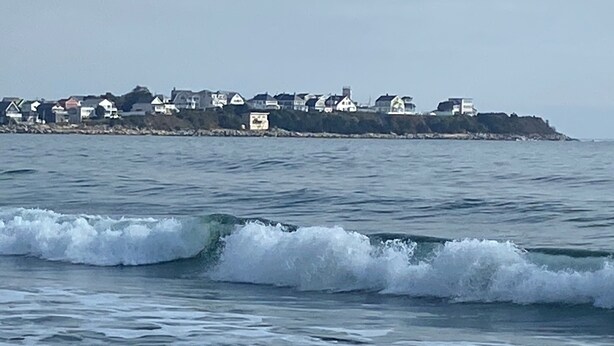 A coastal view with waves approaching the shore.