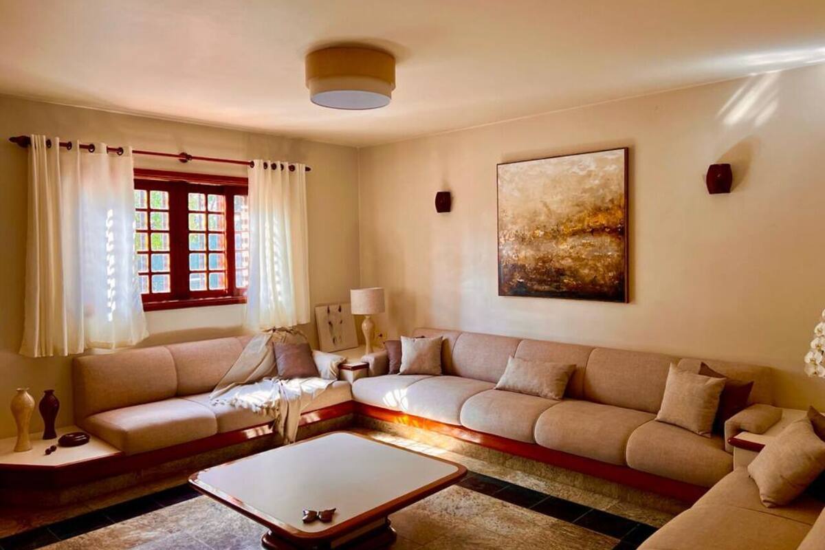 A living room with a sofa, a coffee table, a lamp, and a painting on the wall.