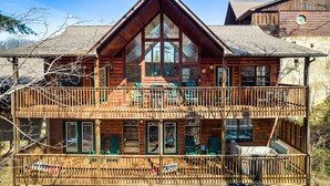 A two-story log cabin with a balcony and large windows. -  Dollywood - Best Location & Value (Sevierville)