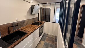 Eine moderne Küche mit Holzarbeitsplatte, weißen Schränken und einem großen Fenster.