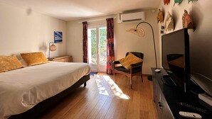 Ein Schlafzimmer mit Bett, Stuhl, Schreibtisch und Fernseher.