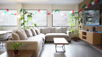 A modern living room with a sectional sofa, a coffee table, and potted plants.