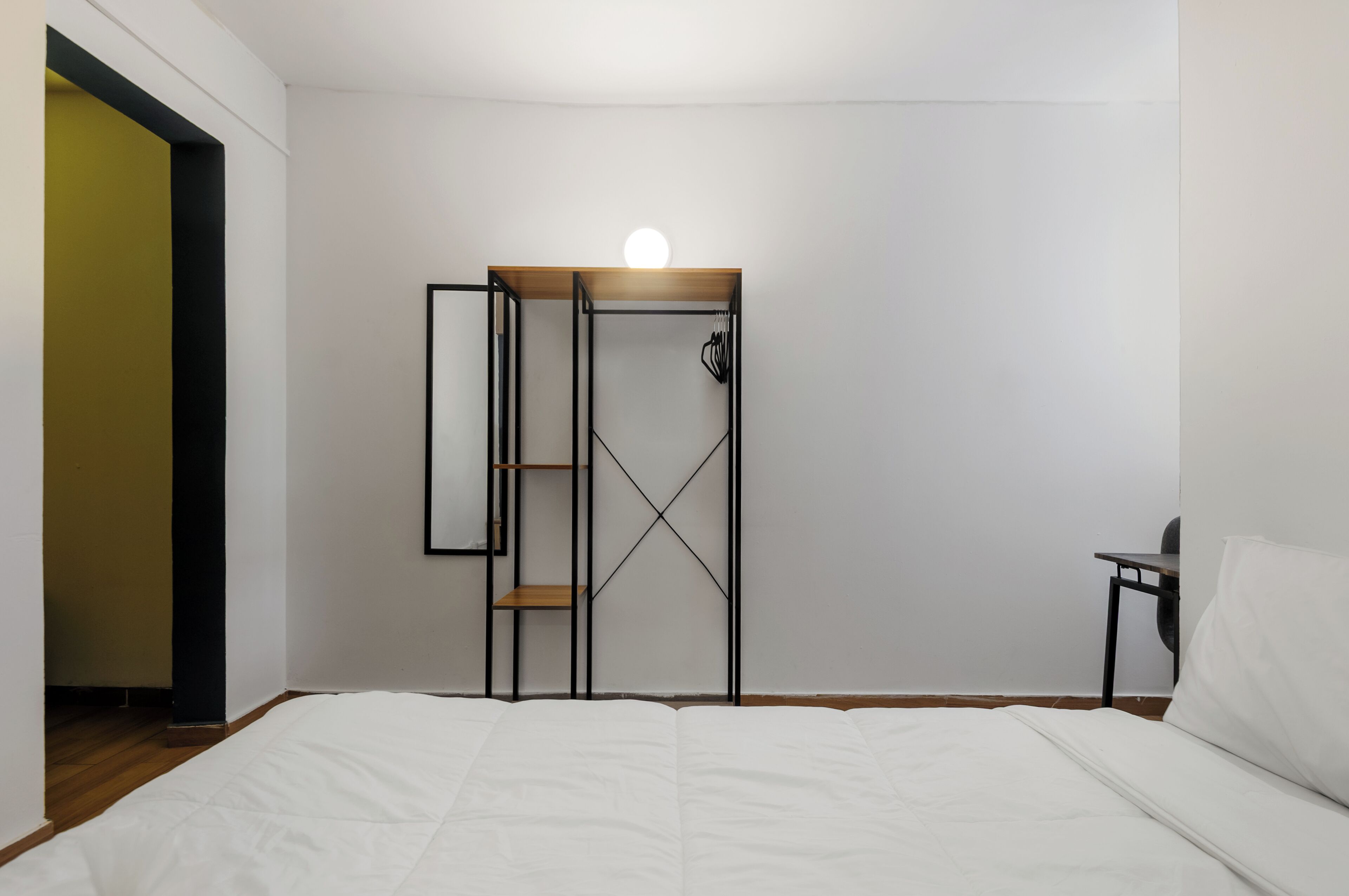 Un dormitorio con una cama, un armario y una mesita.