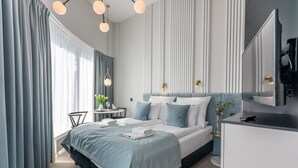 Ein modernes Hotelzimmer mit einem großen Bett, einem Schreibtisch und einem Spiegel.