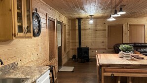 Un interno in legno con angolo cottura, mobili in legno, un fornello e un tavolo da pranzo.