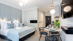 Ein modernes Hotelzimmer mit Bett, Nachttischen, einem Schreibtisch und einer Essecke.