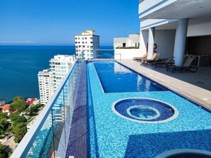 A rooftop infinity pool with a clear view of the ocean and surrounding buildings. - Polanco Residences Ambar Roca Santa Marta - Colombia (Santa Marta)