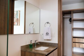 A bathroom with a wooden vanity, a mirror, a sink, and a towel rack. - Polanco Residences Ambar Roca Santa Marta - Colombia (Santa Marta)