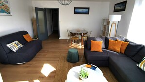 Un salon moderne avec un canapé, une table basse et un coin repas.