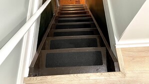 A staircase leading to a landing with a doormat. - Carriage House Studio in the Heart of DC (Washington)
