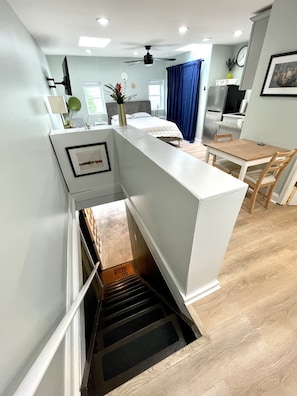 En moderne lejlighed med et køkken, spiseområde og et soveværelse med en stor seng og et natbord.