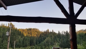 A wooden structure with a view of a forested hillside. - A Cabin in Rochford (Hill City)