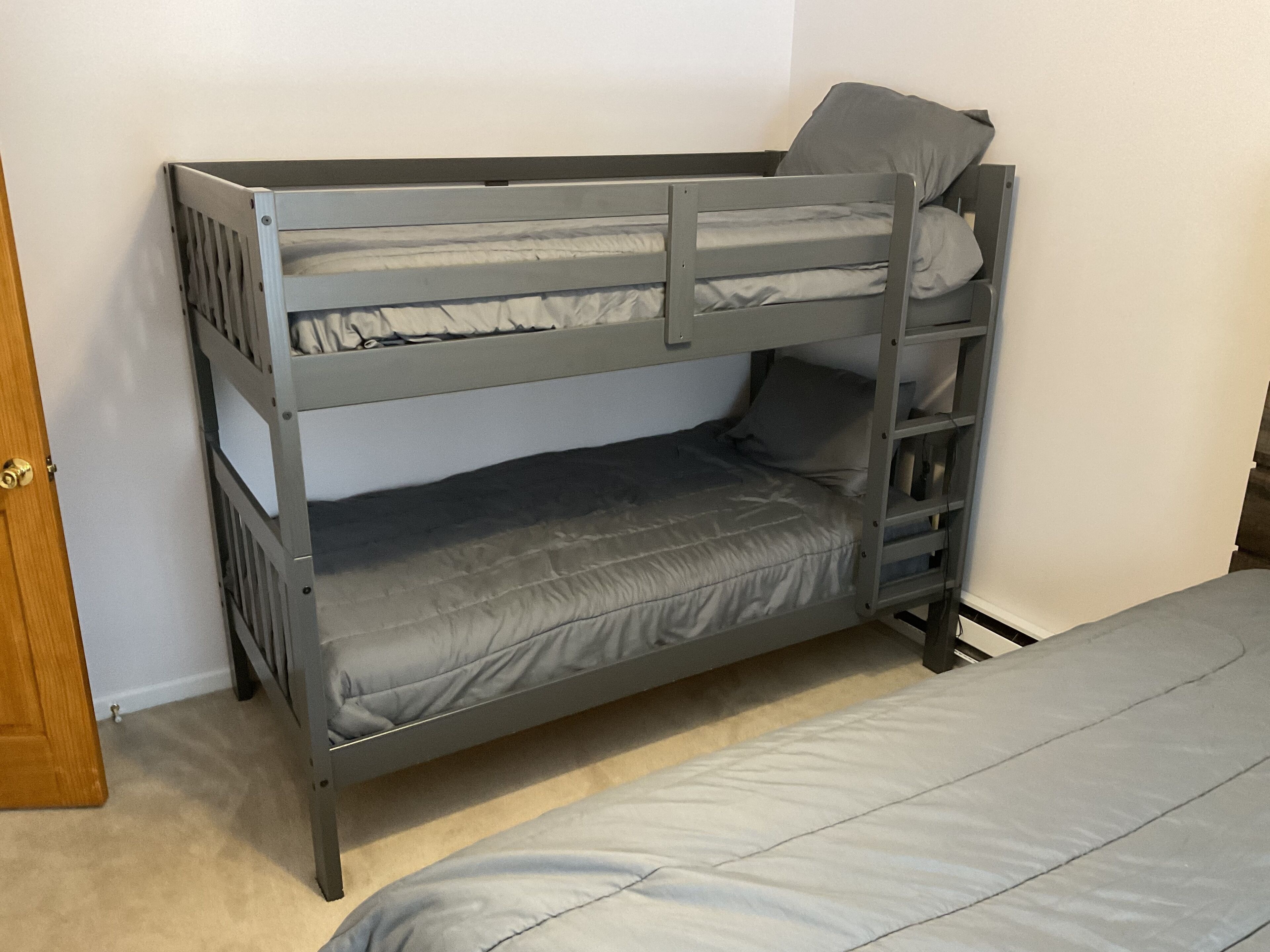 Un letto a castello con un letto inferiore e un materasso sul pavimento.