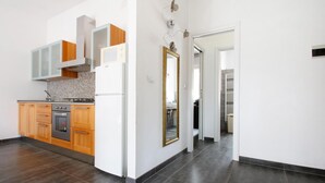 A modern kitchen with wooden cabinets, a built-in oven, and a white refrigerator.