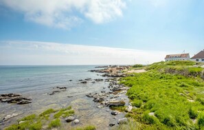 A coastal landscape with a clear view of the sea, rocky shoreline, and a building with a red roof. - Nice apartment in Allinge with WiFi (Allinge)