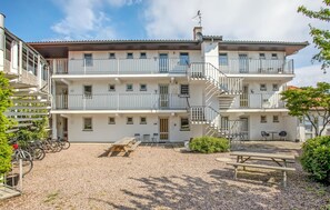A multi-story building with balconies, a covered outdoor seating area, and a gravel courtyard. - Nice apartment in Allinge with WiFi (Allinge)