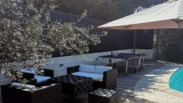 Un espace extérieur aménagé avec une terrasse, une piscine, une plateforme en bois et des coins salon.