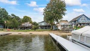 Una propiedad junto al lago con muelle, casas y un bote.