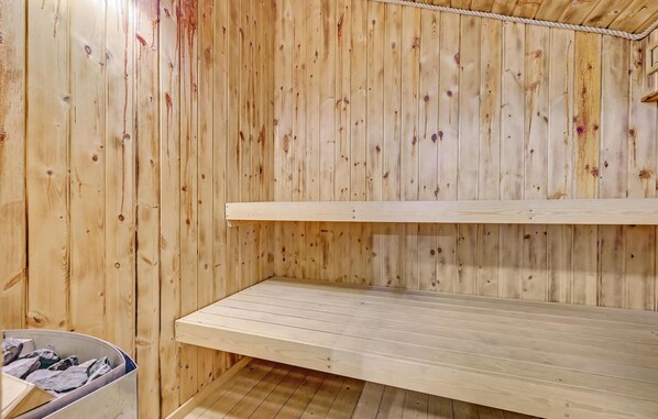 A sauna room with wooden walls and benches.