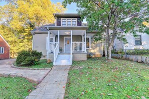 Stunning two-story home with a charming front porch and beautifully manicured lawn.