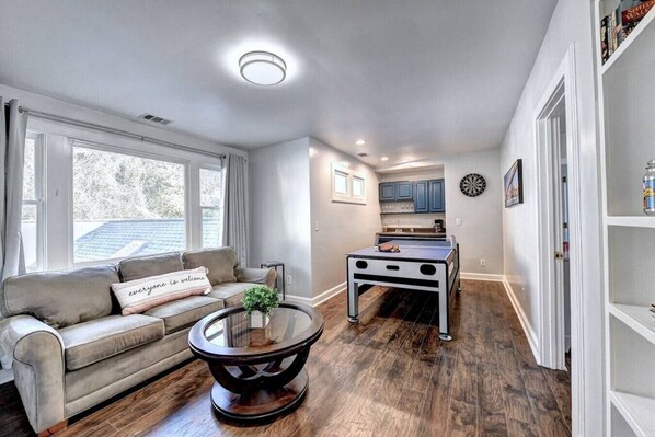 Cozy living space with a sofa, coffee table, and kitchenette, perfect for a relaxing stay.
