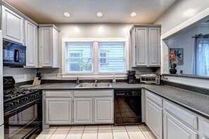 Enjoy cooking in this well-equipped kitchen with a central island, gas stove, double sink, and ample counter space.