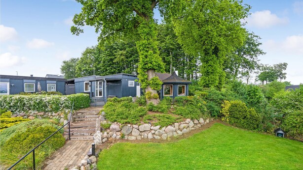 En rad med blåa husvagnar, med gångvägar av sten och en gräsyta.