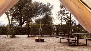 An outdoor area with a fire pit, benches, and a pergola structure. - Sequoia Dawn  (Three Rivers)