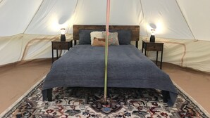 A tent with a bed, two bedside tables, and a patterned rug. - Sequoia Dawn  (Three Rivers)
