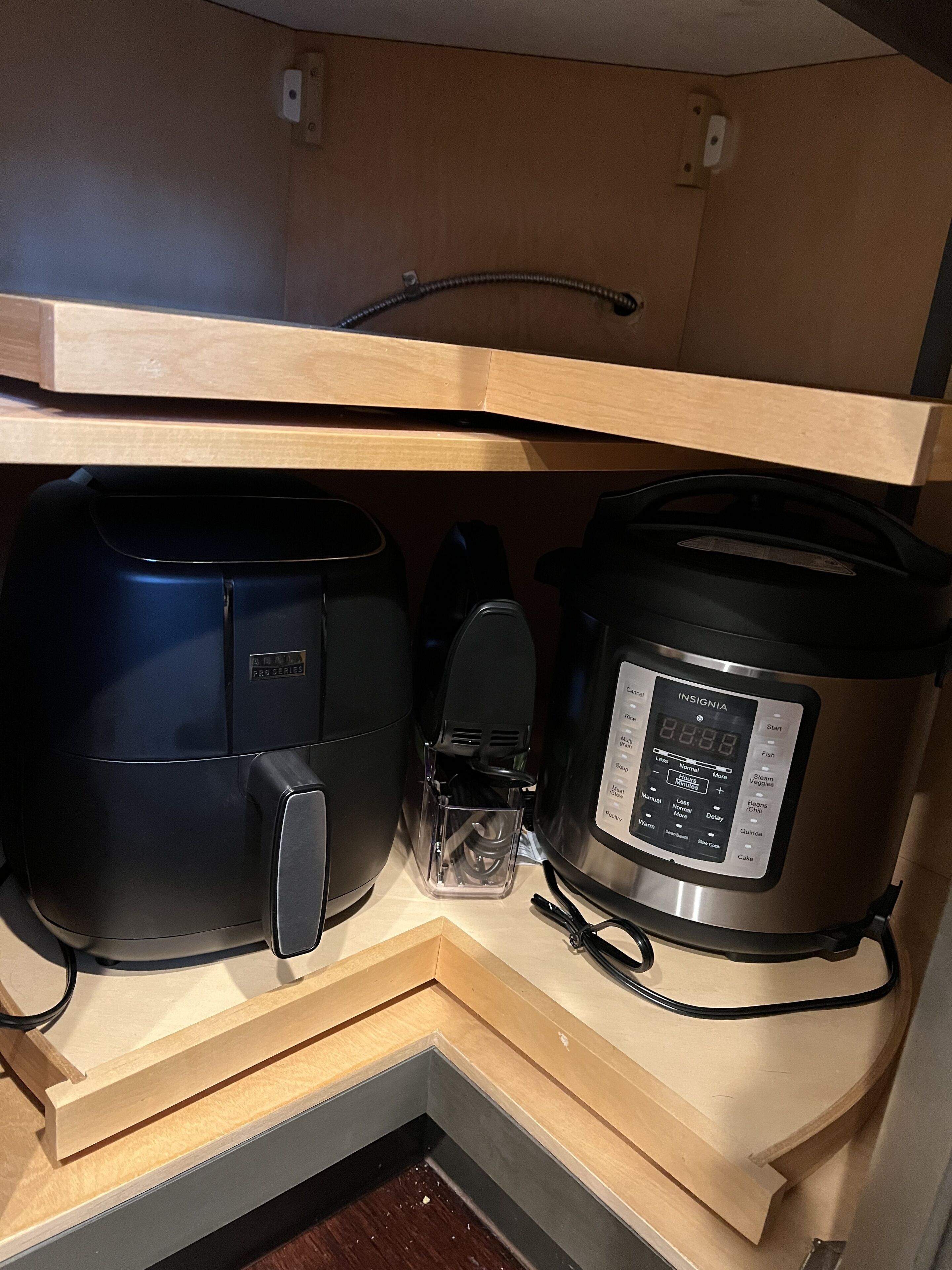 A kitchen with a built-in oven and a slow cooker.