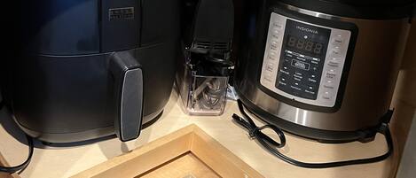 A kitchen with a built-in oven and a slow cooker.