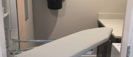 A medical examination room with a white examination table, a wall-mounted Electrolux Quiet Clean vacuum cleaner, and a wooden floor.